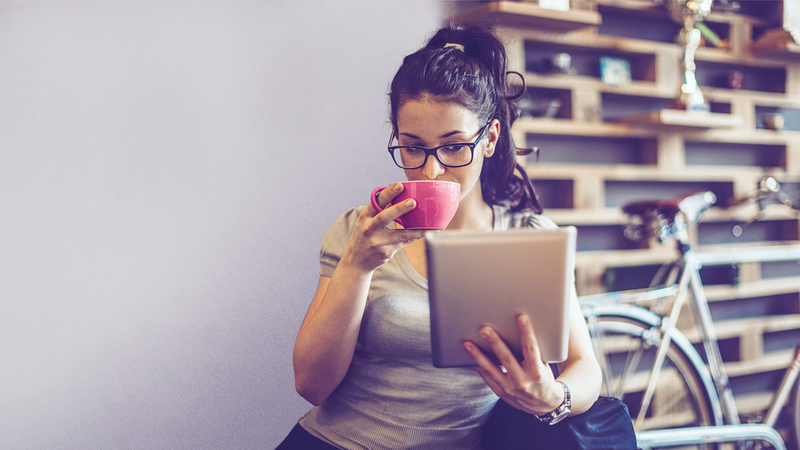 ConnectedCare Partner, Skoobe, junge Frau trinkt Kaffee und liest eBook auf Tablet